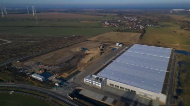 Yeni büyük lojistik merkezi inşaatı devam ediyor. Geniş bir depolama alanı, yükleme limanları ve çevresindeki boş araziler var. rotasyon tavası sol panorama genel görünüm drone