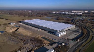 Yeni büyük lojistik merkezi inşaatı devam ediyor. Geniş bir depolama alanı, yükleme limanları ve çevresindeki boş araziler var. geniş yörünge görünümü dronu