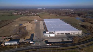 Yeni büyük lojistik merkezi inşaatı devam ediyor. Geniş bir depolama alanı, yükleme limanları ve çevresindeki boş araziler var. Drone görüntülerini daire içine al