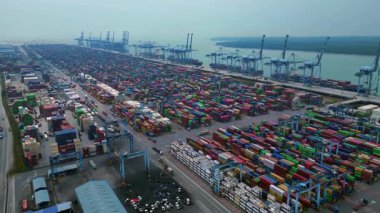 Port Klang 'ın hava görüntüsü çok sayıda renkli kargo konteynırları ve gantry vinçleri olan hareketli bir nakliye terminalini gösteriyor. Uçarken üstten uçmak İHA 'yı ileri itmek