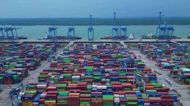 Hız rampası Klang limanının batısında çok sayıda nakliye konteynırı, kamyon ve vinç ile birlikte geniş bir konteynır görüntüsü. panorama genel görünümü dolly sol drone