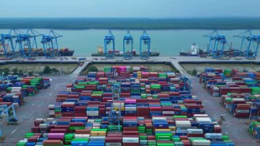 Hız rampası Klang limanının batısında çok sayıda nakliye konteynırı, kamyon ve vinç ile birlikte geniş bir konteynır görüntüsü. Ters panorama görünümü dronu uçur