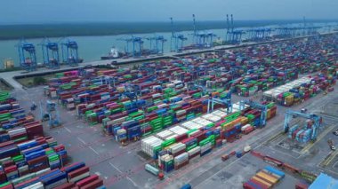Hız rampası Klang limanının batısında çok sayıda nakliye konteynırı, kamyon ve vinç ile birlikte geniş bir konteynır görüntüsü. panorama üst uçuş insansız hava aracı