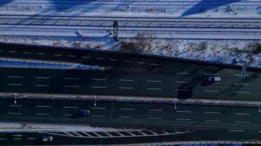 Berlinde yoğun bir otoyol, binalar ve açık bir kış gününde karla kaplı yerleşim alanları var. Üstten kumandalı hava aracı kameraları aşağıya bakıyor.