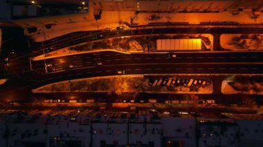 Berlin sokağı kış boyunca gece vakti yukarıdan görüldü. Parlak sokak lambaları karla kaplı çatılar ve yoğun yollar aydınlatıyor. dikey kuş bakışı dron