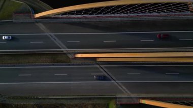 Nehir üzerindeki modern bir Alman otoban köprüsünün tepeden aşağı görüntüsü. İki yönde de araçlar hareket ediyor. statik tripodlar İHA görüntüsünün tepesinde geziniyor