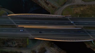 Nehir üzerindeki modern bir Alman otoban köprüsünün tepeden aşağı görüntüsü. İki yönde de araçlar hareket ediyor. Yukarıdan drone atışı