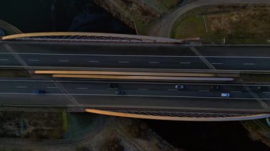 Nehir üzerindeki modern bir Alman otoban köprüsünün tepeden aşağı görüntüsü. İki yönde de araçlar hareket ediyor. Aşağıya bakan İHA kamerası