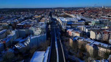 Berlin, Almanya 'da açık kış havasında eşsiz bierpinsel binası ve karlı çatıların havadan görünüşü. Sinek ileri itme panorama genel görünüm drone