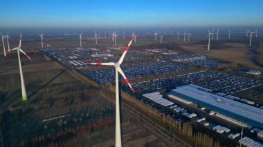 Geniş bir araba dağıtım merkezi ve araç parkına yenilenebilir enerji sağlayan büyük bir rüzgar çiftliği. İHA panorama genel görüntüsü alçalıyor