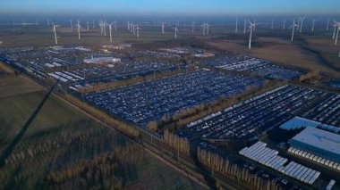 Geniş bir araba dağıtım merkezi ve araç parkına yenilenebilir enerji sağlayan büyük bir rüzgar çiftliği. Ters İHA uçuşu