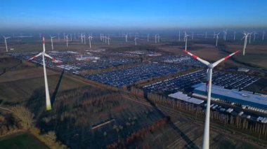 Geniş bir araba dağıtım merkezi ve araç parkına yenilenebilir enerji sağlayan büyük bir rüzgar çiftliği. İticileri ileri çalıştır