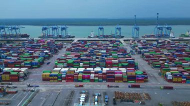 Sayısız nakliye konteynırı, kanat vinci ve kargo gemisi olan büyük bir konteynır limanının havadan görüntüsü. panorama genel görünüm dronu