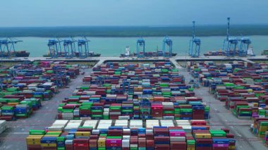 Sayısız nakliye konteynırı, kanat vinci ve kargo gemisi olan büyük bir konteynır limanının havadan görüntüsü. panorama genel görünümü statik panorama süzülen drone