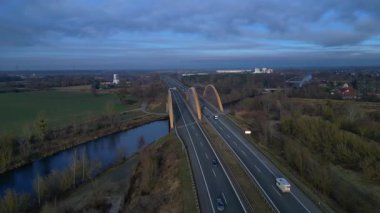 Alman otoyol köprüsü nehir üzerinde araç trafiğini taşıyor ve peyzajları birbirine bağlıyor. panorama yörünge dronu