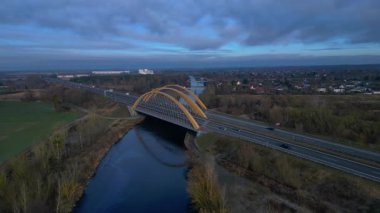 Alman otoyol köprüsü nehir üzerinde araç trafiğini taşıyor ve peyzajları birbirine bağlıyor. Geniş yörünge panorama görünümü insansız hava aracı