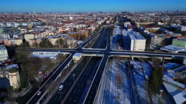 Berlin şehir manzarası, kış günlerinde karmaşık bir yol ağı, trafik akışı, demiryolu hatları ve binaları gösteriyor. Hız rampası hiper hareket zamanı hızlandırılmış panorama yörünge dronu