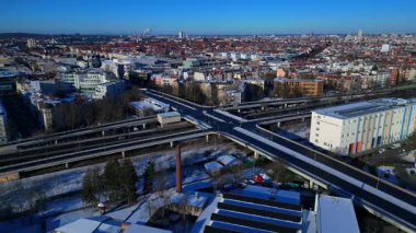 Berlin şehir manzarası, kış günlerinde karmaşık bir yol ağı, trafik akışı, demiryolu hatları ve binaları gösteriyor. durağan panorama havada süzülen insansız hava aracı