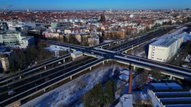 Berlin şehir manzarası, kış günlerinde karmaşık bir yol ağı, trafik akışı, demiryolu hatları ve binaları gösteriyor. Geniş yörünge panorama görünümü insansız hava aracı