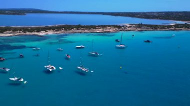 Turkuaz Akdeniz suları, tekneler ve güneşli gökyüzünün altında Estany Pudent tuz düzlükleri olan kıyı şeridi. rotasyon tavası sol drona