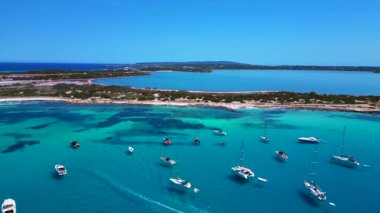 Turkuaz Akdeniz suları, tekneler ve güneşli gökyüzünün altında Estany Pudent tuz düzlükleri olan kıyı şeridi. İHA panorama genel görüntüsü alçalıyor