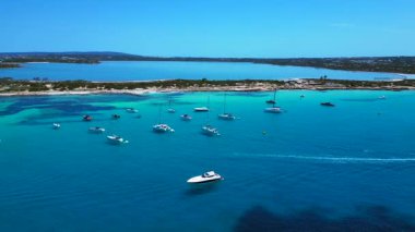 Turkuaz Akdeniz suları, tekneler ve güneşli gökyüzünün altında Estany Pudent tuz düzlükleri olan kıyı şeridi. Sinek ileri itme panorama genel görünüm drone