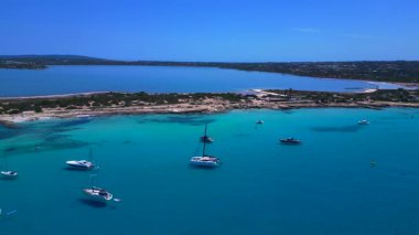 Turkuaz Akdeniz suları, tekneler ve güneşli gökyüzünün altında Estany Pudent tuz düzlükleri olan kıyı şeridi. statik panorama havada süzülen drone
