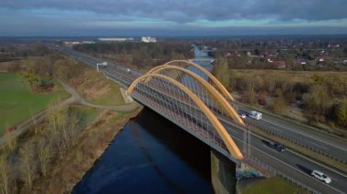 Alman otoyol köprüsü nehir üzerinde araç trafiğini taşıyor ve peyzajları birbirine bağlıyor. panorama yörünge dronu