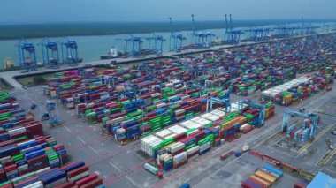 Hava görüntüsü, iskele tarafında renkli nakliye konteynırları ve büyük vinçlerle batı limanını gösteriyor. Hız rampası hiper hareket zamanı hızlandırılmış panorama genel görünüm dronu