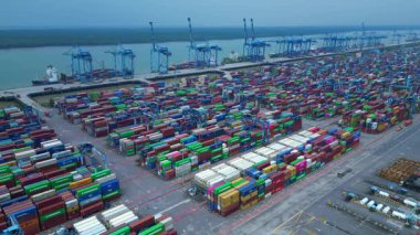 Hava görüntüsü, iskele tarafında renkli nakliye konteynırları ve büyük vinçlerle batı limanını gösteriyor. statik panorama havada süzülen drone