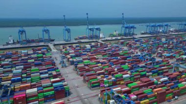 Hava görüntüsü, iskele tarafında renkli nakliye konteynırları ve büyük vinçlerle batı limanını gösteriyor. statik panorama havada süzülen drone