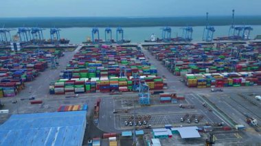 Hava görüntüsü, iskele tarafında renkli nakliye konteynırları ve büyük vinçlerle batı limanını gösteriyor. rotasyon pan 'dan sağ drona