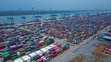 Hava görüntüsü, iskele tarafında renkli nakliye konteynırları ve büyük vinçlerle batı limanını gösteriyor. Geniş yörünge panorama görünümü insansız hava aracı