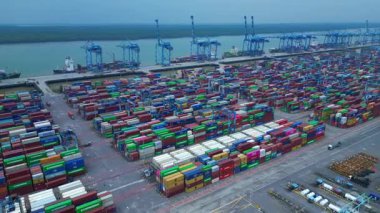 Hava görüntüsü, iskele tarafında renkli nakliye konteynırları ve büyük vinçlerle batı limanını gösteriyor. Geniş yörünge panorama görünümü insansız hava aracı