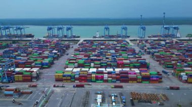 Sayısız nakliye konteynırı, kanat vinci ve kargo gemisi olan büyük bir konteynır limanının havadan görüntüsü. panorama genel görünümü dolly sol drone
