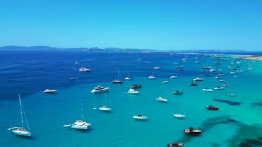 Formentera Balearic Adası 'nın berrak turkuaz sularına demirlenmiş pek çok zevk teknesinin hız rampası hızlandırılmış hareket süresi. Ters panorama görünümü dronu uçur