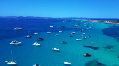 Formentera Balearic Adası 'nın berrak turkuaz sularına demirlenmiş pek çok zevk teknesinin hız rampası hızlandırılmış hareket süresi. Ters İHA uçuşu