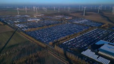 Hız rampası hızlandırılmış zaman aşımı geniş bir rüzgar çiftliği geniş bir araba dağıtım merkezi ve araç otoparkına yenilenebilir enerji sağlıyor. Ters panorama görünümü dronu uçur