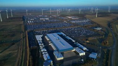 Hız rampası hızlandırılmış zaman aşımı geniş bir rüzgar çiftliği geniş bir araba dağıtım merkezi ve araç otoparkına yenilenebilir enerji sağlıyor. panorama yörünge dronu