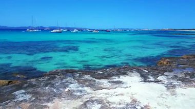 Formentera Balearic Adası 'nın berrak turkuaz sularına demirlenmiş pek çok zevk teknesinin hız rampası hızlandırılmış hareket süresi. uçuş üstü insansız hava aracı