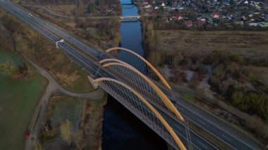 Modern Alman otoyol köprüsünün hız rampası nehir üzerinde araç trafiğini taşıyor ve peyzajları birbirine bağlıyor. Yukarıdan aşağıya doğru uçur