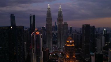 Petronas İkiz Kuleleri, ikonik gökdelenler, modern mimari ve canlı kentsel yaşamla etkileyici bir şehir silueti oluşturuyorlar. statik panorama havada süzülen drone