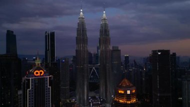 Petronas İkiz Kuleleri, ikonik gökdelenler, modern mimari ve canlı kentsel yaşamla etkileyici bir şehir silueti oluşturuyorlar. statik panorama havada süzülen drone