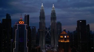 Petronas İkiz Kuleleri, ikonik gökdelenler, modern mimari ve canlı kentsel yaşamla etkileyici bir şehir silueti oluşturuyorlar. statik panorama havada süzülen drone