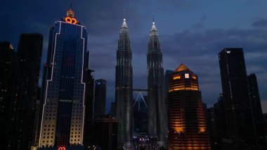 Petronas İkiz Kuleleri, ikonik gökdelenler, modern mimari ve canlı kentsel yaşamla etkileyici bir şehir silueti oluşturuyorlar. İHA alçalıyor