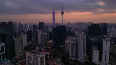 Kuala Lumpur şehri, kentsel gelişimi temsil eden aydınlık Merdeka 118 gökdeleni ve KL Kulesi 'nin yer aldığı güzel bir günbatımında ufuk çizgisine sahiptir. panorama genel görünüm dronu