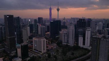 Kuala Lumpur şehri, kentsel gelişimi temsil eden aydınlık Merdeka 118 gökdeleni ve KL Kulesi 'nin yer aldığı güzel bir günbatımında ufuk çizgisine sahiptir. statik panorama havada süzülen drone
