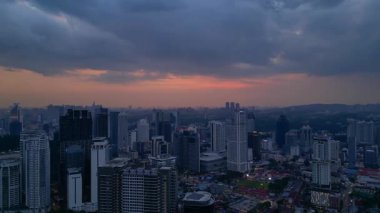Kuala Lumpur şehri, kentsel gelişimi temsil eden aydınlık Merdeka 118 gökdeleni ve KL Kulesi 'nin yer aldığı güzel bir günbatımında ufuk çizgisine sahiptir. rotasyon tavası sol drona