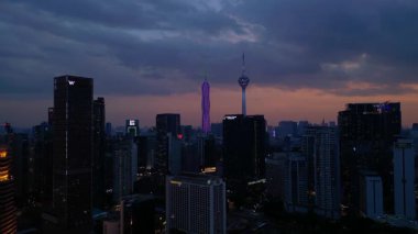 Kuala Lumpur şehri, kentsel gelişimi temsil eden aydınlık Merdeka 118 gökdeleni ve KL Kulesi 'nin yer aldığı güzel bir günbatımında ufuk çizgisine sahiptir. panorama genel görünüm dronu
