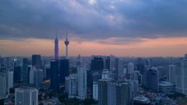 Kuala Lumpur şehri, kentsel gelişimi temsil eden aydınlık Merdeka 118 gökdeleni ve KL Kulesi 'nin yer aldığı güzel bir günbatımında ufuk çizgisine sahiptir. rotasyon tavası sol drona
